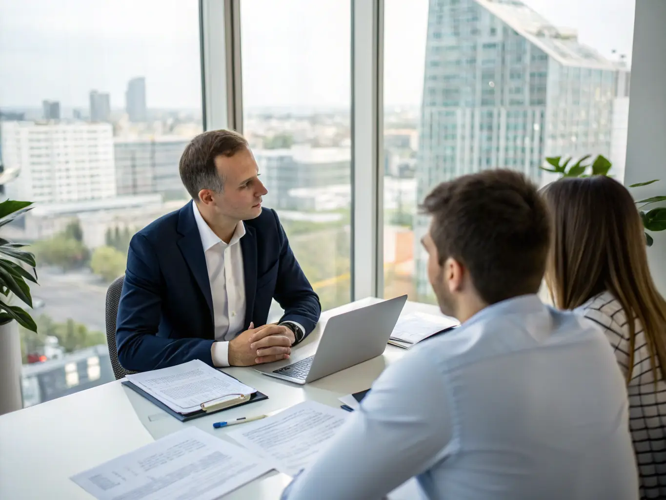 An image of a professional consultation with clients reviewing investment portfolios and market data.